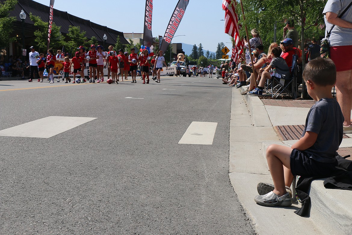 A youngster watches as Strikers soccer players take part the Sandpoint Lions Fourth of July parade on Tuesday.