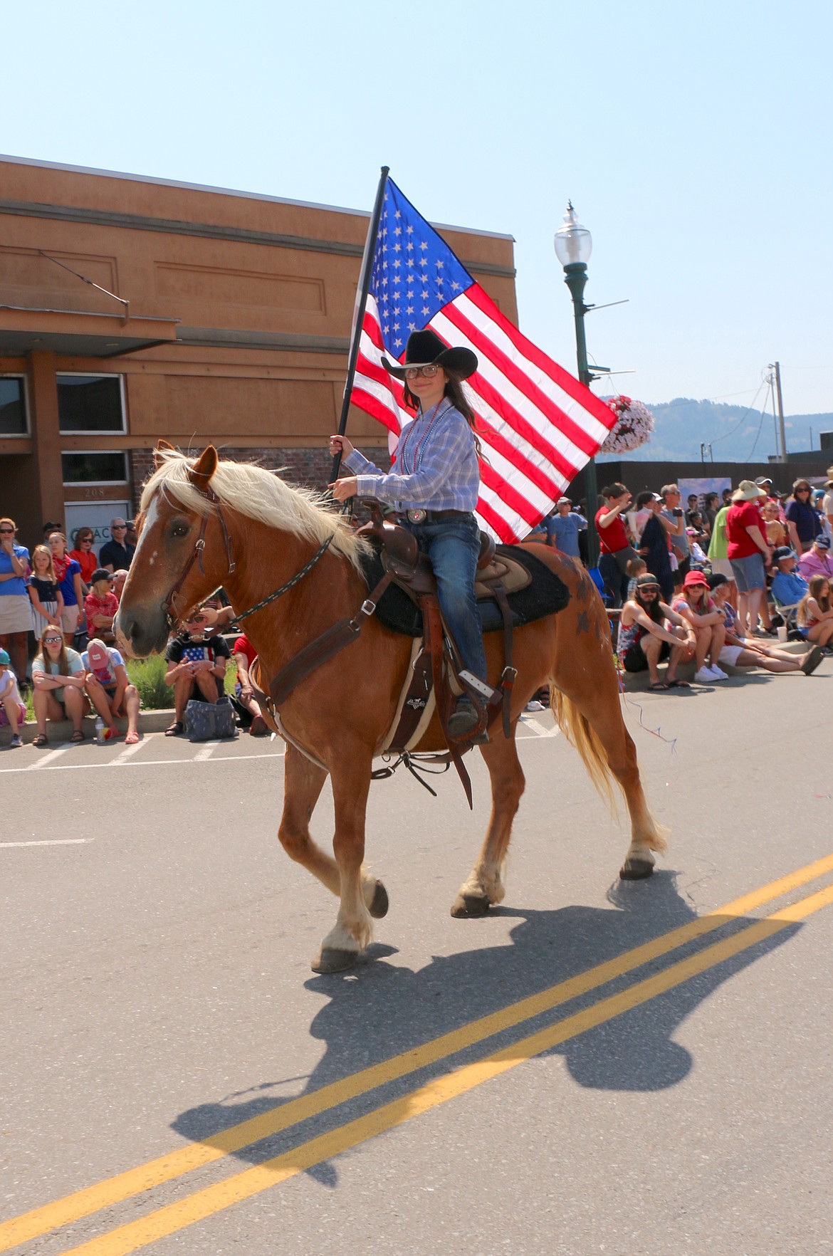 A young cowgirls brings a western flair to the Fourth as she takes part in the Sandpoint Lions grand parade in Sandpoint on Tuesday.