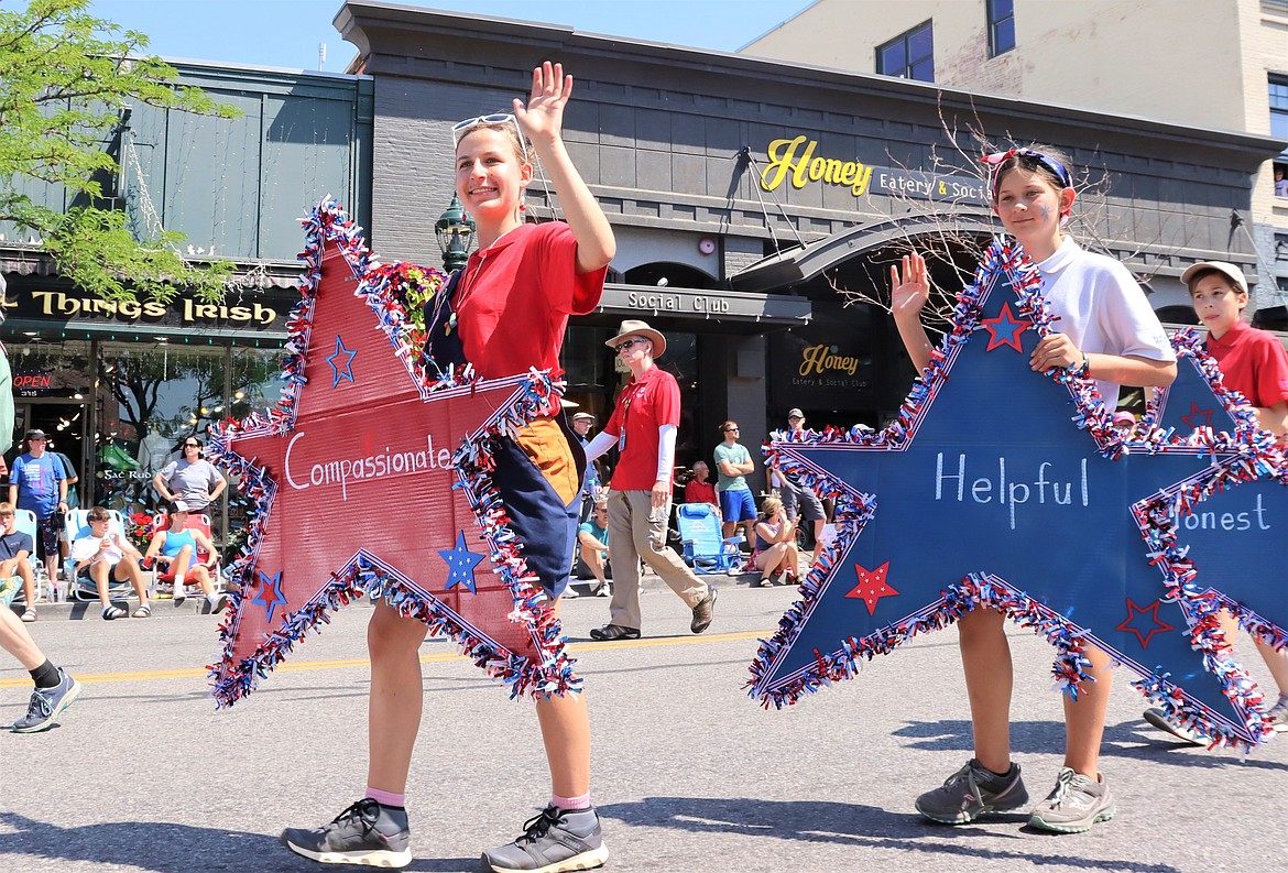 Members with American Heritage Girls march in the Fourth of July parade on Sherman Avenue.