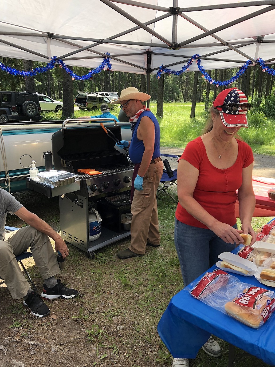 The Yaak community celebrated the Fourth of July with food and fellowship, including grilled hot dogs by "master chefs" Steven and Victora Kass. (Photo courtesy Sandy Beder-Miller)