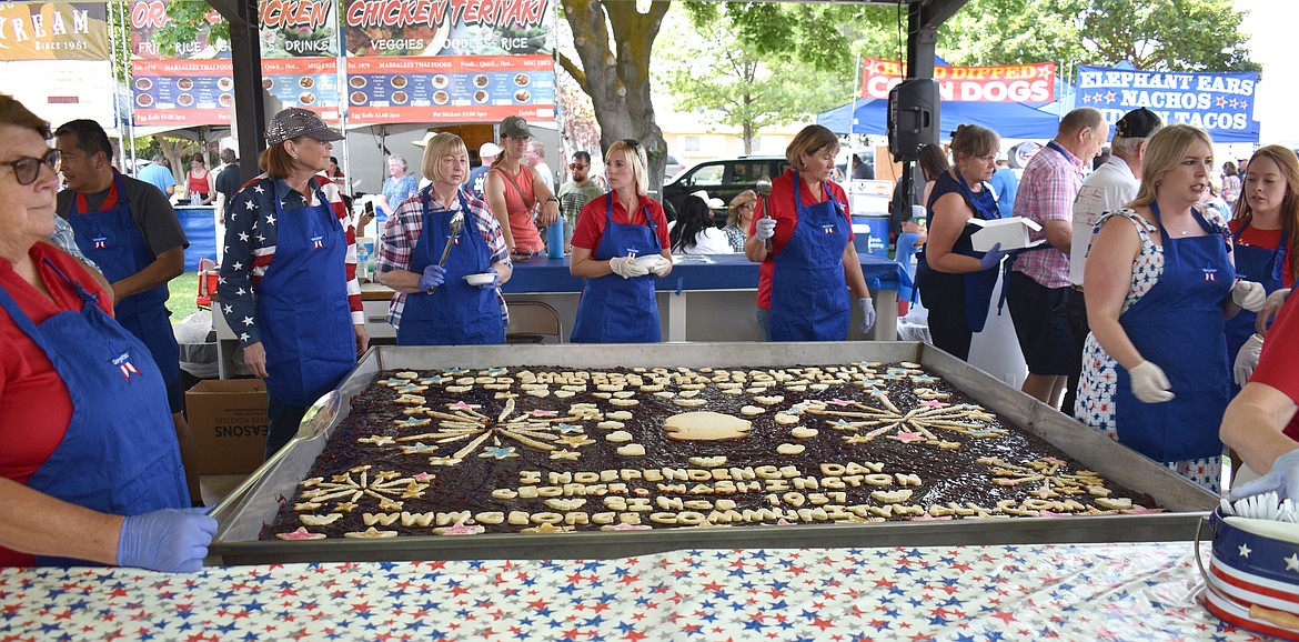 The Georgettes prepare to serve the 64-square-foot cherry pie in George Tuesday. The pie has been an Independence Day tradition since the town was founded in 1957.