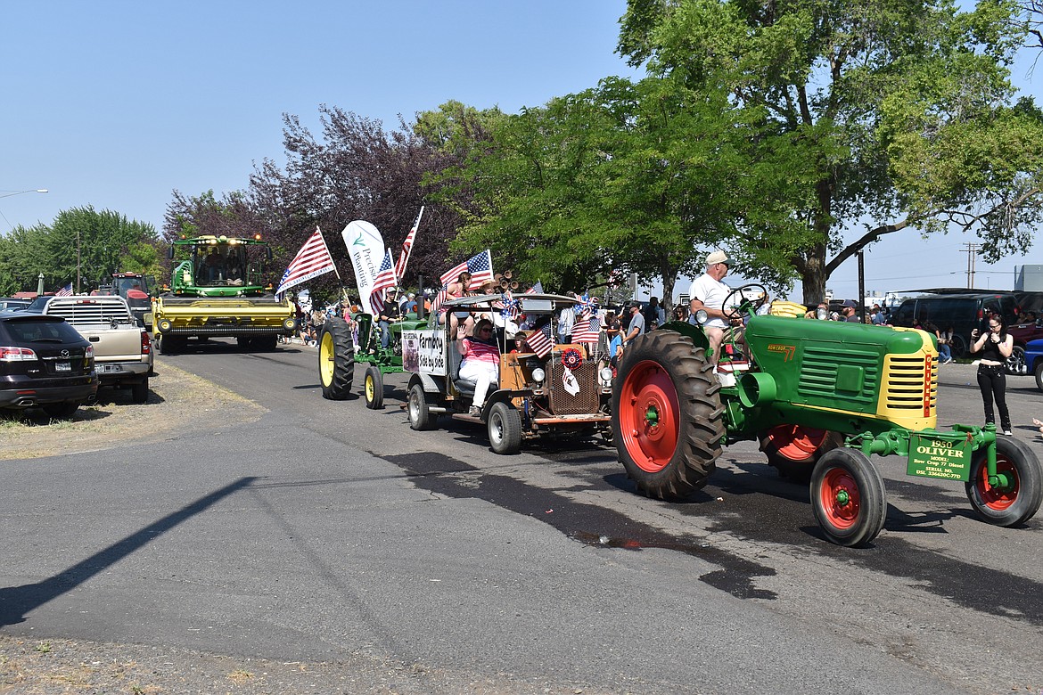 Farm equipment old and new rolls down Montmorency Boulevard in George Tuesday as part of the town’s Independence Day parade.