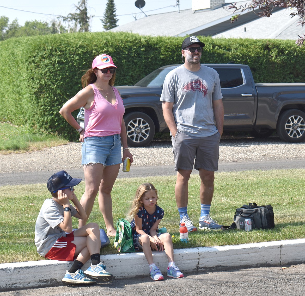 Jen and Cullen Kunkel wait with their children Weston, 9, left, and Rhys, 4, for the Fourth of July parade to begin Tuesday morning in George. The Kunkels came from Venice, California to spend the holiday in Cullen’s hometown, they said.