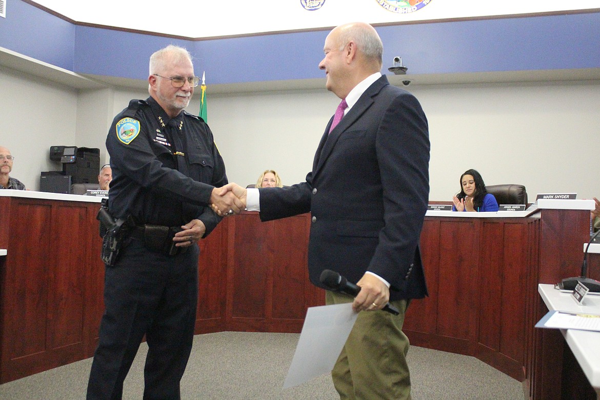 New Othello Police Chief Dave Rehaume, left, shakes hands with Othello Mayor Shawn Logan after the swearing-in ceremony. Rehaume had served as interim chief after former chief Phil Schenck retired from the force in May.