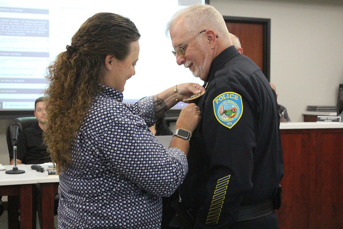 Dave Rehaume’s chief’s badge is pinned on by his wife Amanda. Rehaume has served in law enforcement for more than three decades.