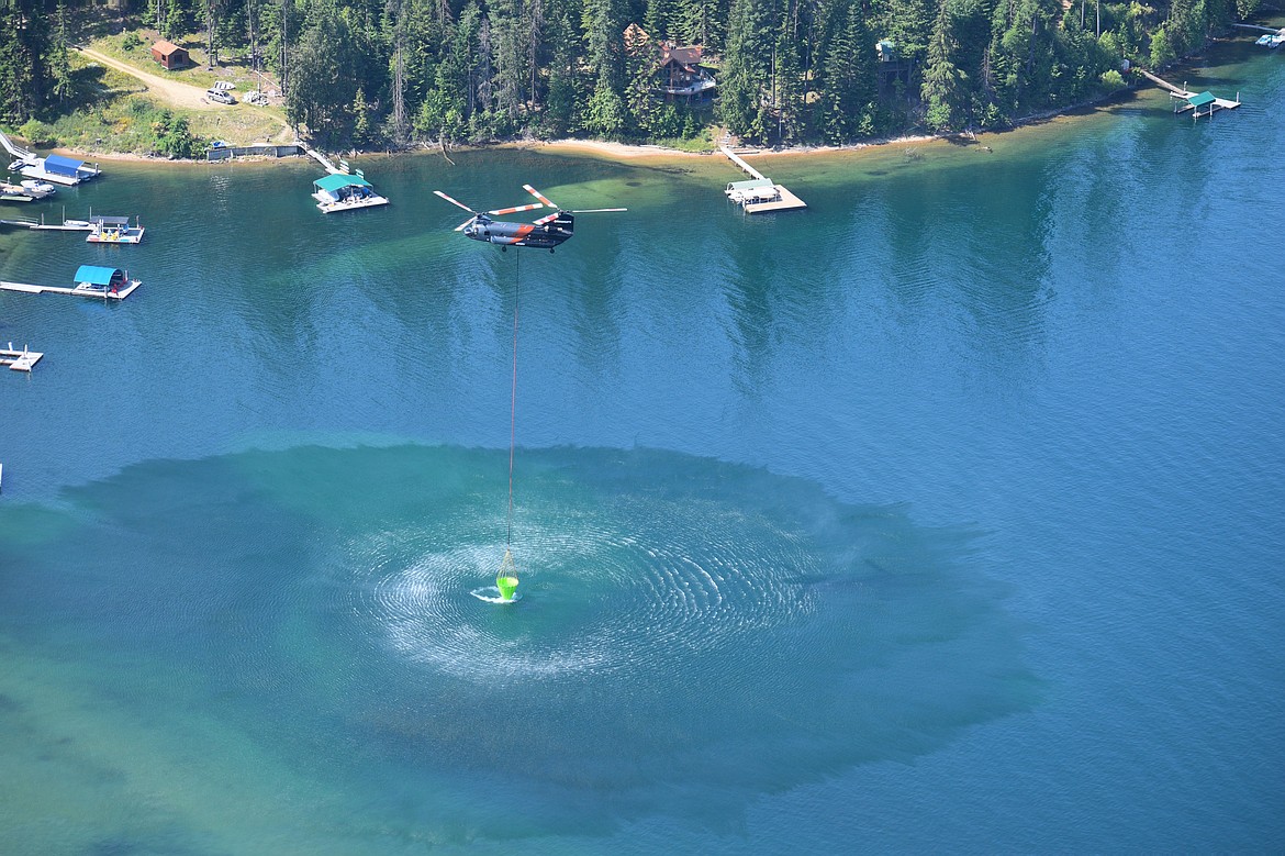 A helicopter scoops up water Thursday at Hayden Lake to fight a fire on the east end of the lake.