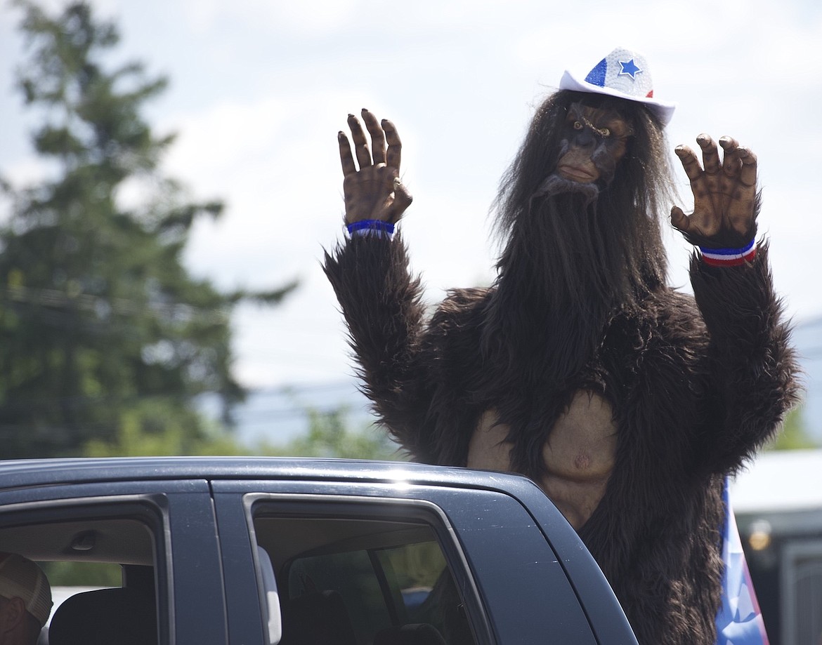 Someone dressed in a sasquatch costume in the back of a truck waves to families during Arlee's Independence Day parade. (Max Dupras/Leader)