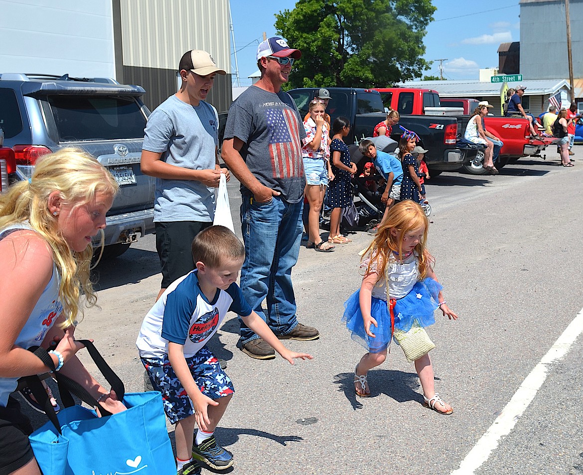 Kids along the Charlo parade route were poised to accumulate candy last Tuesday, including Kaslyn Lyday, far right, who was born on July 4. (Kristi Niemeyer/Leader)