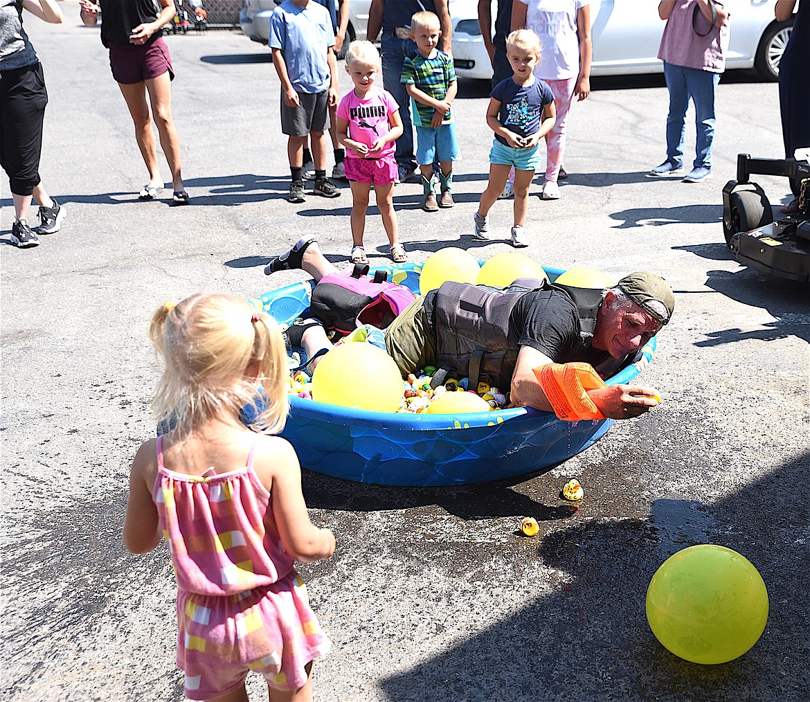 Bruce Vincent dives into a pool of rubber duckies during the Libby Area Chamber of Commerce's 2023 duck race at Ace Home and Garden Center. (Scott Shindledecker/The Western News)