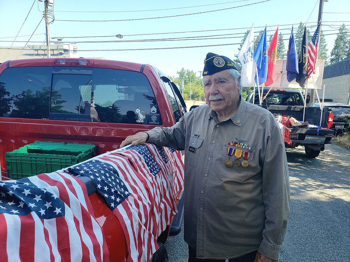 Fort Sherman DAV Chapter 9 Commander Joe Bordelon tapes some American flags to the side of the DAV parade float for the Post Falls parade Saturday.