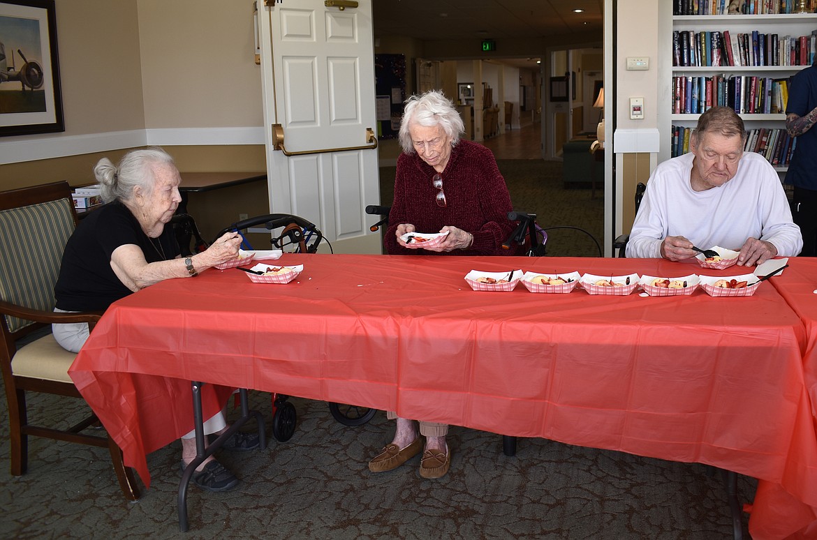 From left, Brookdale Hearthstone residents Lenora Anabel, Dorothy Hurtig and Dave Roberts enjoy their part of a 20-foot strawberry sundae Friday.