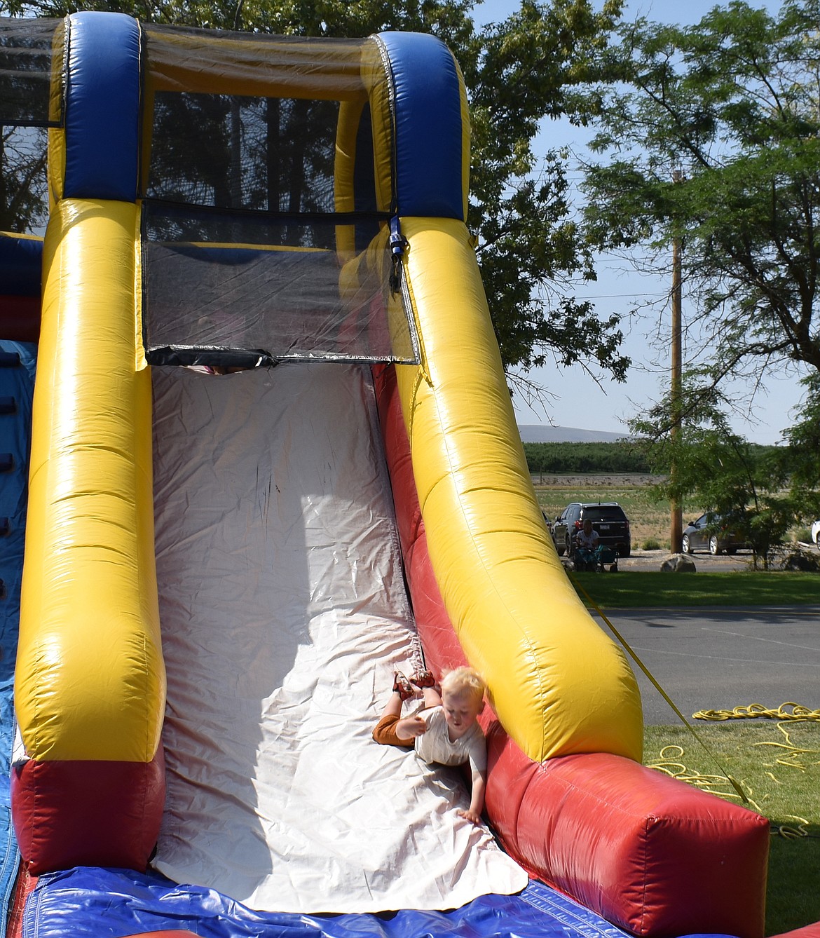 Two-year-old Cooper Van Tatenhove tumbles down an inflatable slide at Summerfest Saturday.