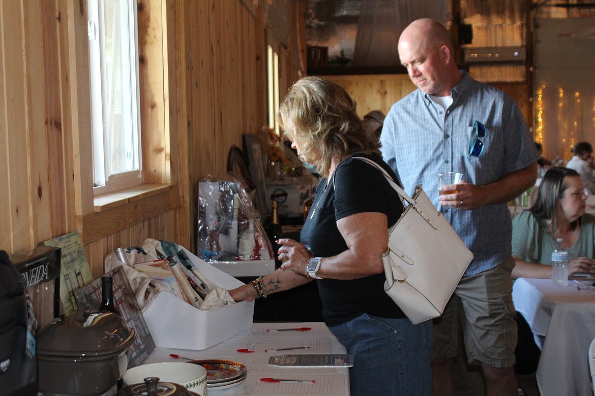 Prospective bidders check out the auction items at the Party for the Paws fundraiser for Adams County Pet Rescue.