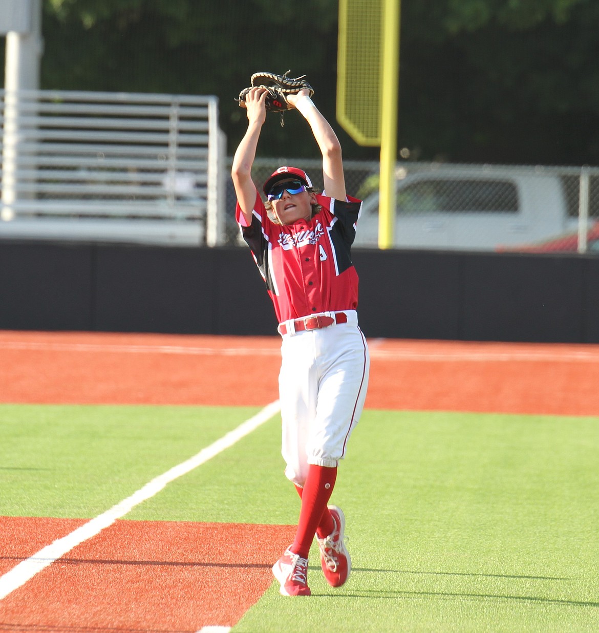 Logan Iverson reaches back in foul territory and squeezes a fly ball in his glove for an out.