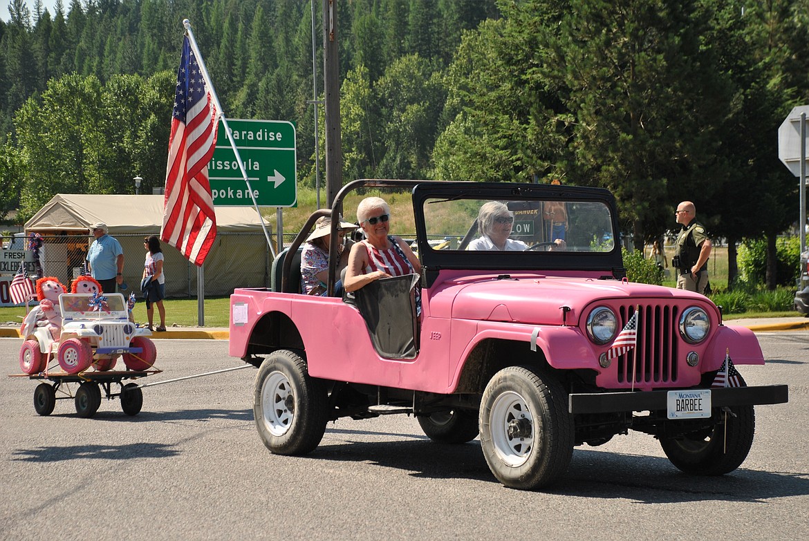 Paula Mintz leans out of a pretty pink jeep pulling along a mini toy jeep on Independence Day. (Mineral Independent/Amy Quinlivan)