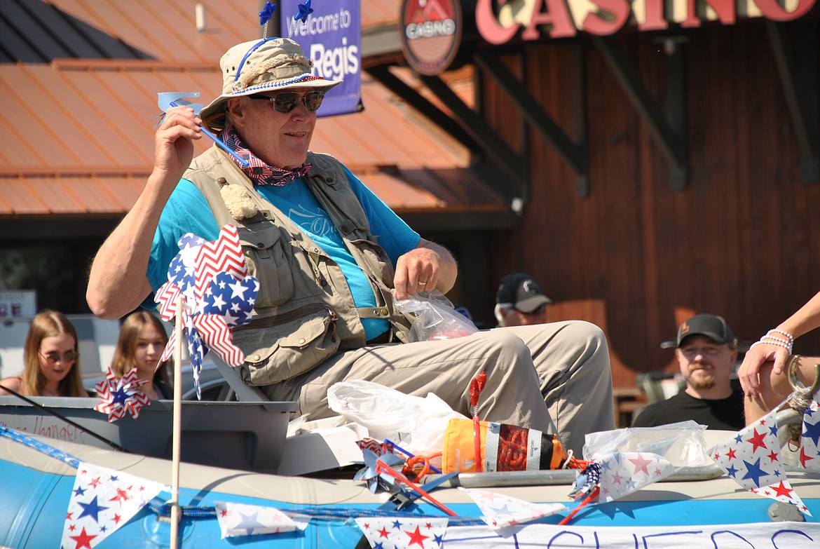 Retired local physician, fly fishermen and Jesus sharing "Doc" Bruce McClelland threw out patriotic pinwheels from the New Day Fellowship float. The river raft on wheels had a sign on the back, "Hooked on Jesus - Fishers of Men!"(Mineral Independent/Amy Quinlivan)