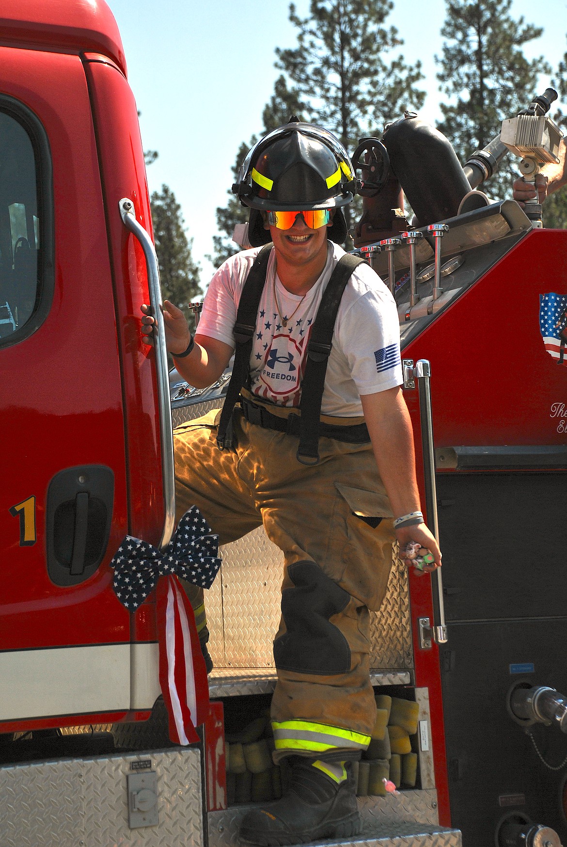 Superior graduate Trevor Wolff, a firefighter on the St. Regis Volunteer Fire Department, tosses a hand full of candy to the crowd. (Mineral Independent/Amy Quinlivan)