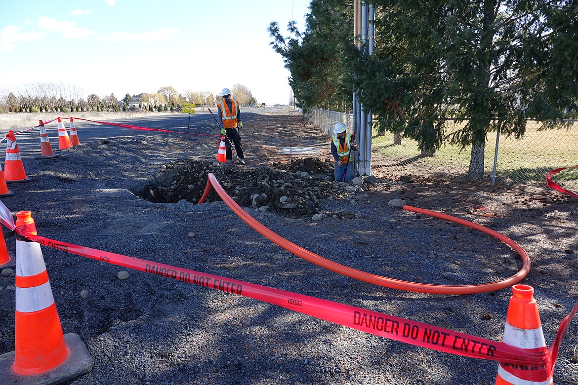 North Sky Communications crews install conduit for a fiber optic line under a roadway. Miles upon miles of similar infrastructure are installed above and below ground throughout Grant County in order to provide residents with high-speed internet access.