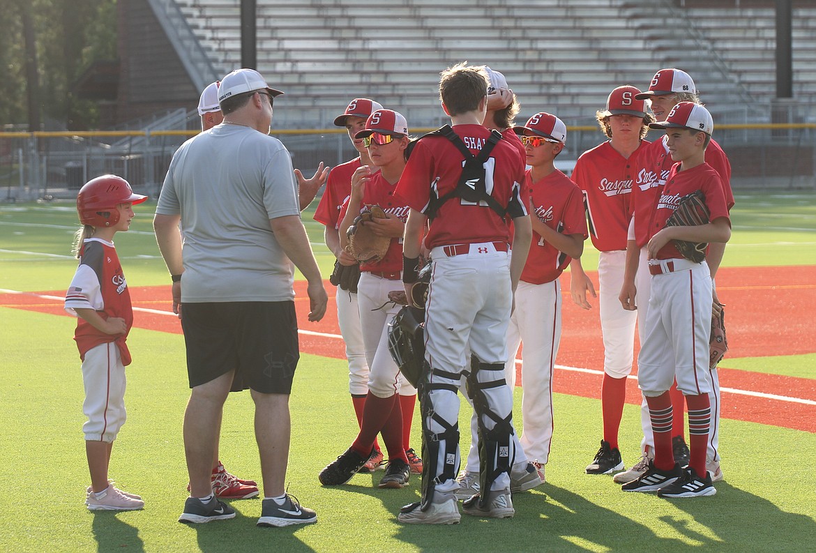 The Sasquatch receive a mid-inning pep talk from their coaches.