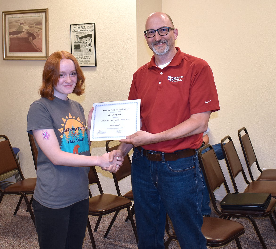 Jake Hollopeter, right, of Anderson Perry, presents Royal High School graduate Rayne Sheriff with a $1,000 scholarship. The engineering firm gives the scholarships to students in about 15 rural communities every year, Hollopeter said.