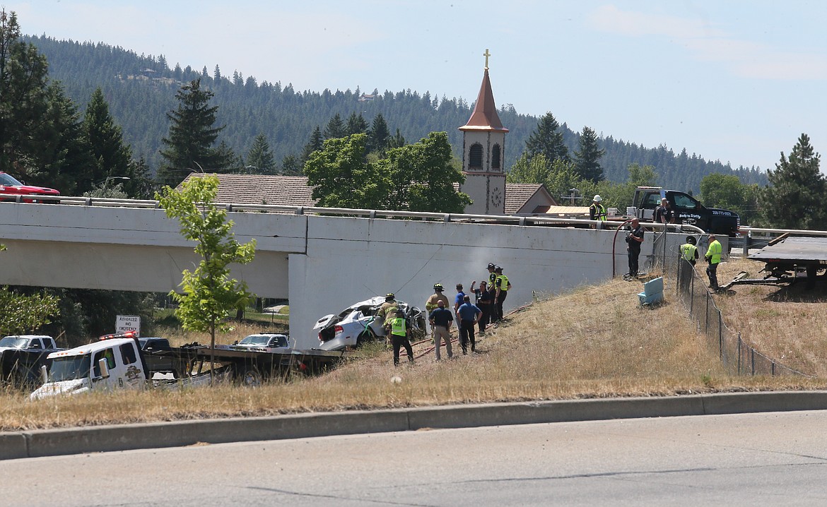 Smoke can still be seen rising from the crash site where a silver sedan on Wednesday drove off westbound Interstate 90 and collided with the Idaho Street Bridge in Post Falls.