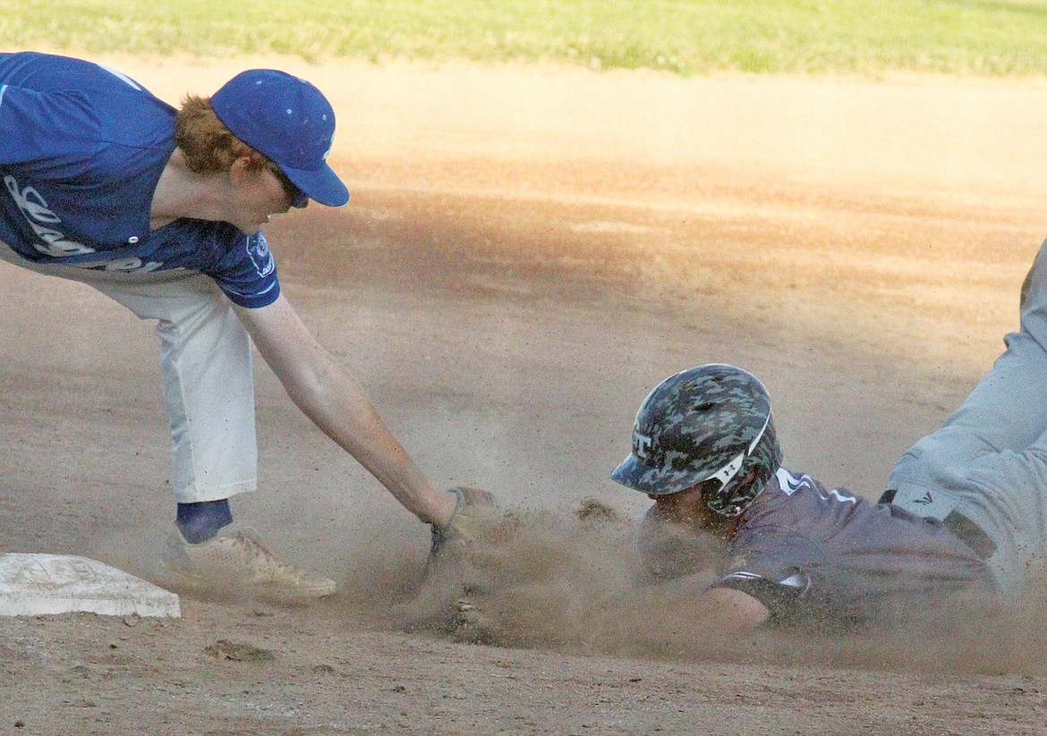 Glacier Twins Kellen Kruger slides head first into the tag of Libby third baseman Caleb Moeller on a throw from catcher Rusty Gillespie for the third out in the top of the fourth inning Wednesday in the second game of a doubleheader. The Twins won, 10-5. ((Paul Sievers/The Western News)