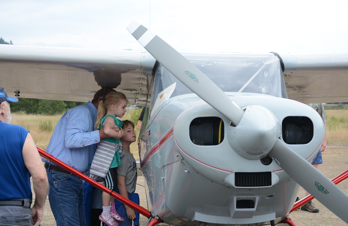 John Struzik, of Coeur d’Alene, holds up Avery Fullmer to get a better view of the interior of an antique plane. John and Mary Struzik took Gabe, Zeke, and 
Avery to Shoshone County airport Tuesday morning to see planes from the Puget Sound Antique Airplane Club air tour.