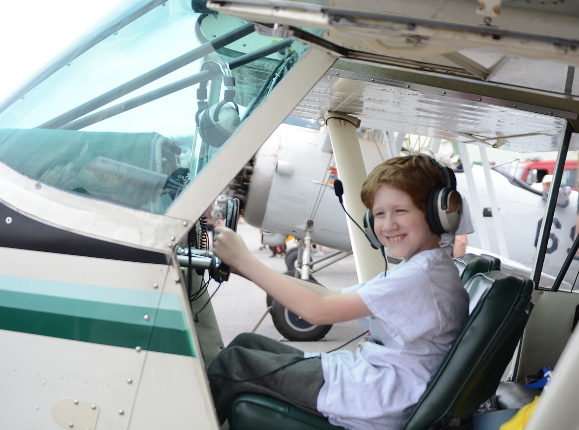 Damion Hooker, 11, of Smelterville, sits in the pilot's seat of an antique airplane.

30 planes visited the Shoshone County airport Tuesday morning and were greeted by a crowd of locals during a stop on the Puget Sound Antique Airplane Club air tour.