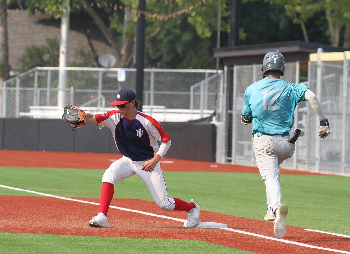 Jayden Kuprienko picks a ball at first base to complete an out.