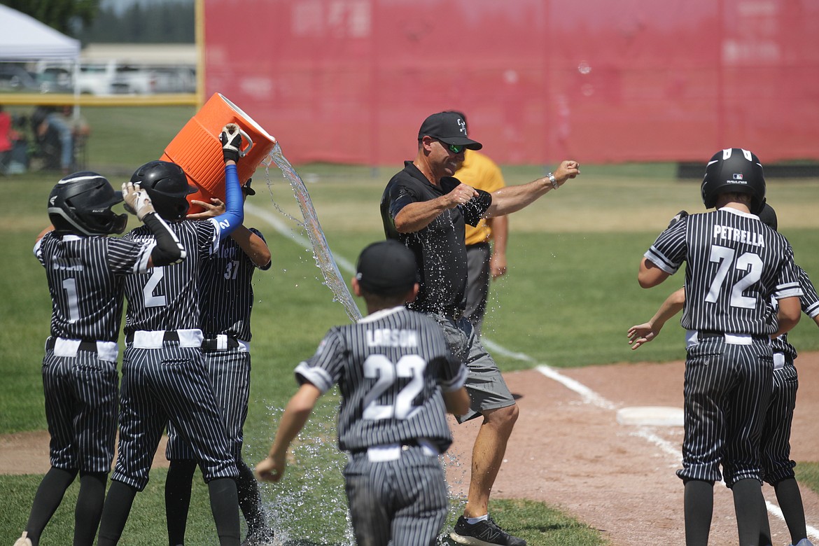 MARK NELKE/Press
Coeur d'Alene players drench manager Dave Everson after the Coeur d'Alene 12U team won the District 1 championship by defeating Sandpoint 11-1 on Saturday at Croffoot Park in Hayden. Coeur d'Alene, which won the best-of-3 series 2-0, advances to state next weekend in Boise.