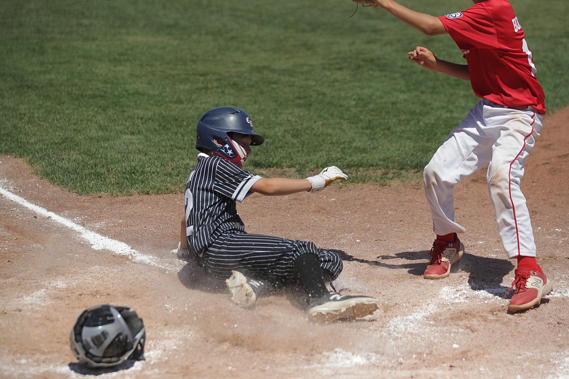 MARK NELKE/Press
JJ Larson of Coeur d'Alene slides home safely as Sandpoint pitcher Kaleb Bogadi covers home Saturday in Game 2 of a best-of-3 series for the District 1 Little League 12U championship at Croffoot Park in Hayden.