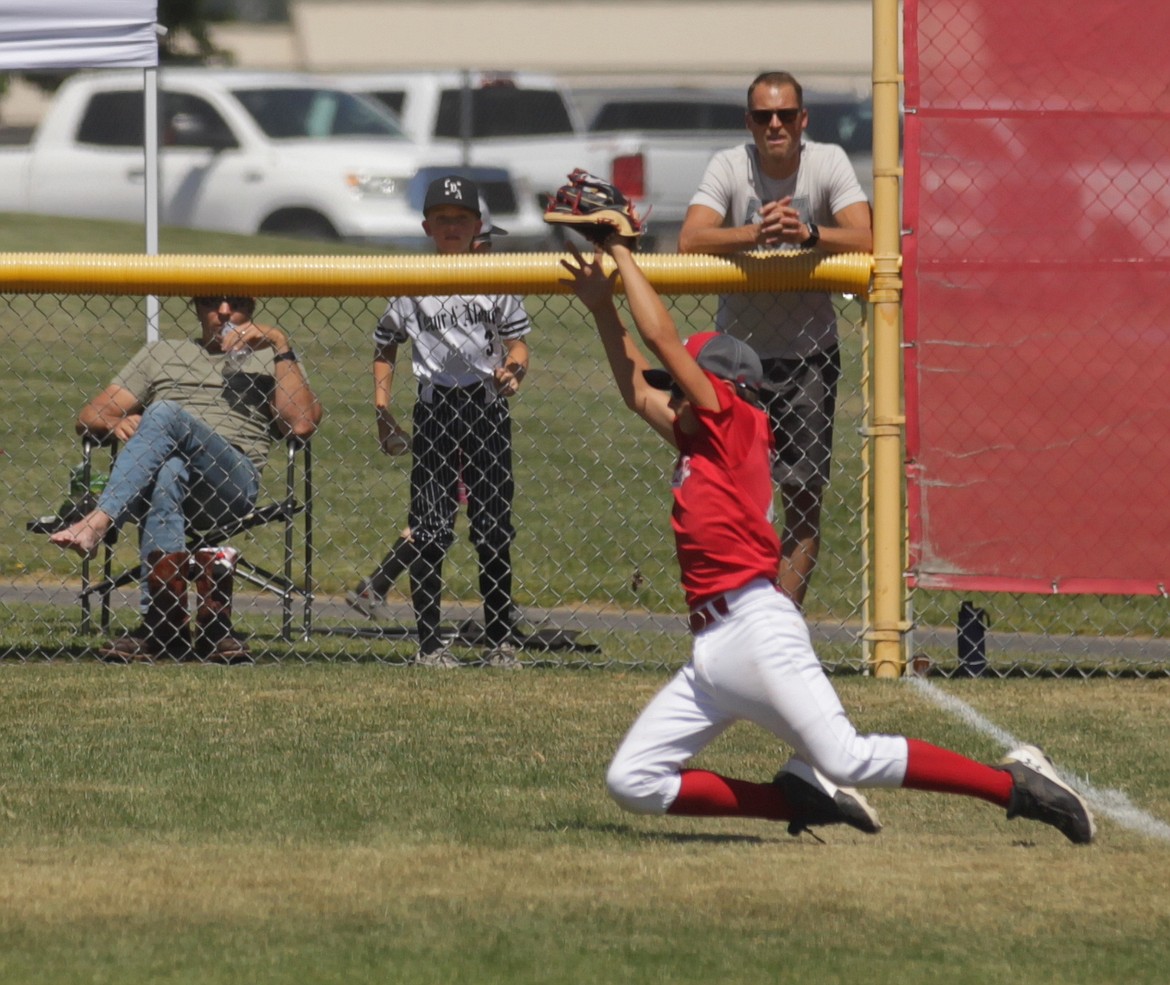 MARK NELKE/Press
Sandpoint left fielder Noah Langlois makes a sliding catch of a fly ball in foul territory on Saturday against Coeur d'Alene in Game 2 of a best-of-3 series for the District 1 Little League 12U championship at Croffoot Park in Hayden.