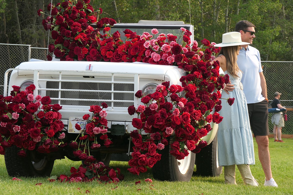 A couple gets a photo in front of an International covered in roses at the Under the Big Sky music festival on Friday, July 14, 2023. (Matt Baldwin/Daily Inter Lake)