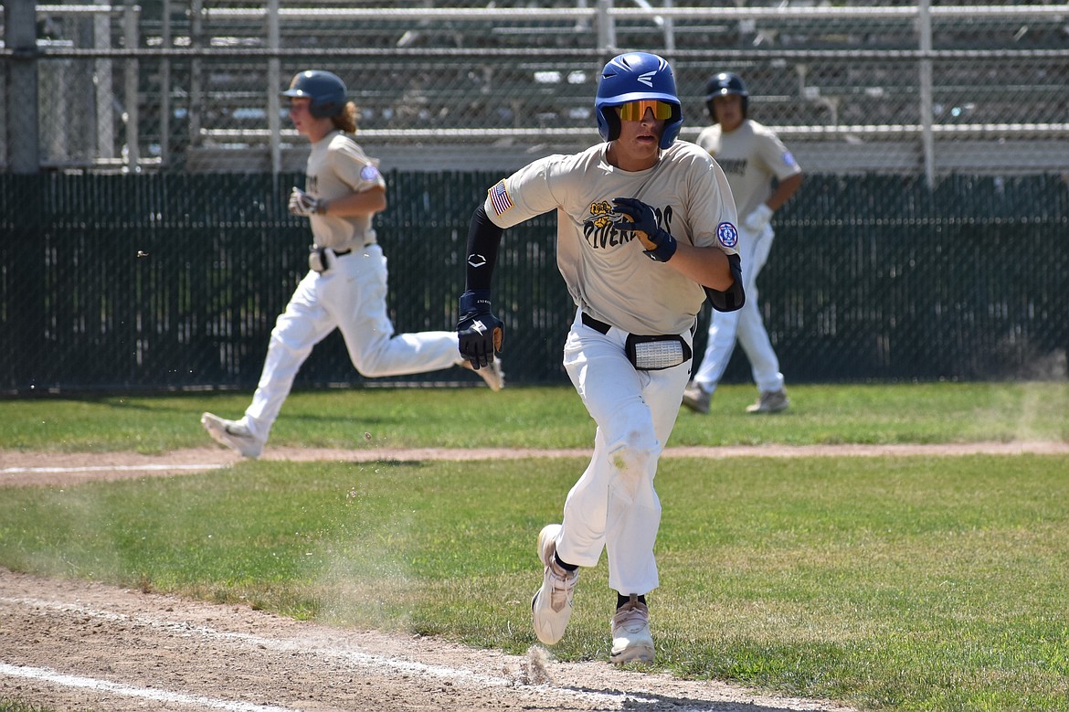 River Dog Kolby Lyons, foreground, runs to first base after making contact with a pitch against the Stilly Venom on July 7.