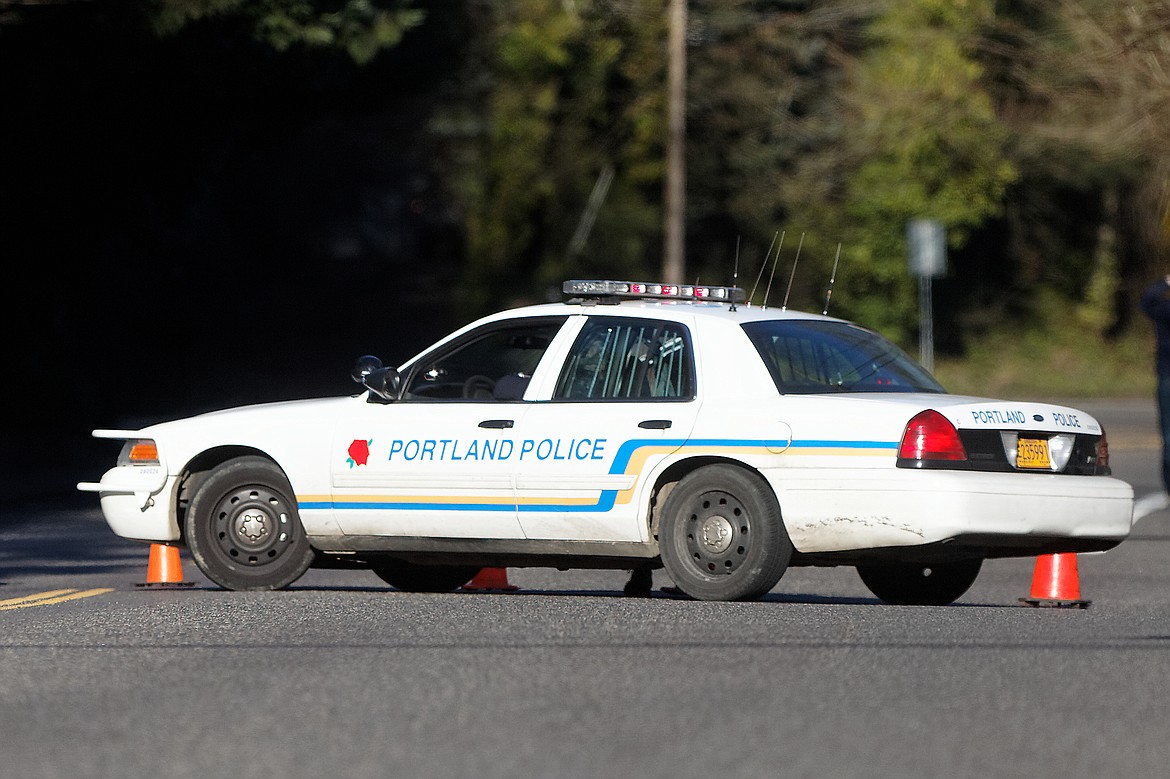 A Portland police vehicle is parked at a crime scene in Portland, Ore., on March 12, 2014. Authorities in Oregon say the deaths of four women whose bodies were found over three months starting in February 2023, with the last one found in May, are linked and that at least one person of interest has been identified. In Portland, the Multnomah County District Attorney's office says no charges have been filed against anyone but added that the community is not currently in any danger. (Mike Zacchino/The Oregonian via AP, File)