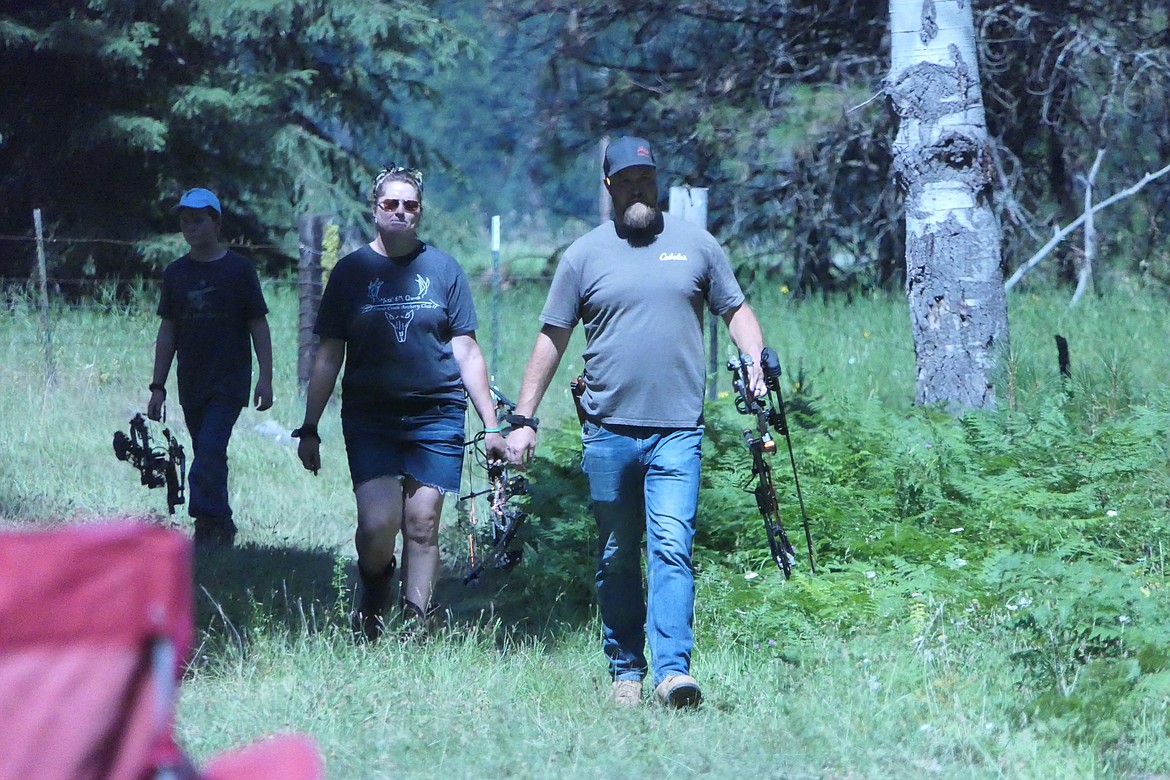 A family of archers emerges from the woods after completing half the 30-stop target shooting course  as part of the Burgers and Bows 3D Shoot Saturday near Trout Creek. (Chuck Bandel/VP-MI)