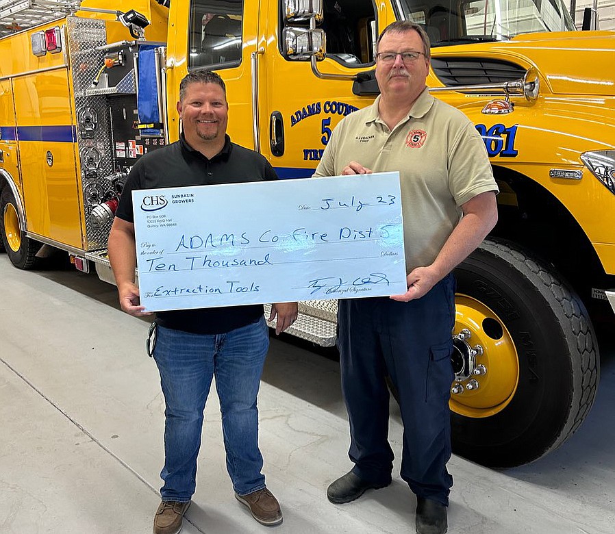 Tyson Chick of CHS Sun Basin Growers, left, presents a check to Adams County Fire District 5 Chief Gary Lebacken.