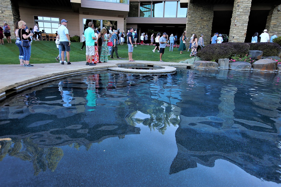 Visitors stand near a pool at Hagadone Gardens at Casco Bay during the "Finish the Journey" fundraiser for Companions Animal Center on Tuesday.