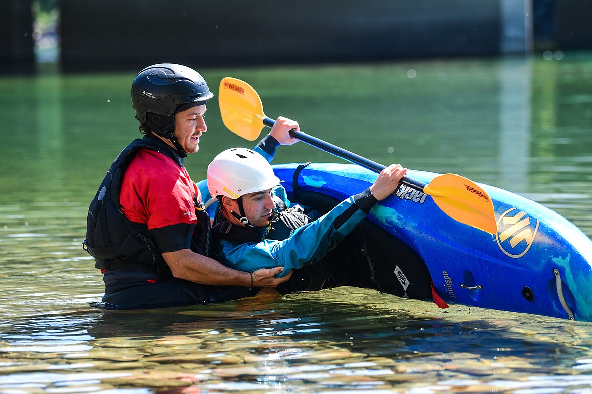 Dave Meyers, left, with Montana Kayak Academy, instructs Daily Inter Lake reporter Adrian Knowler on performing a roll at the Teakettle Fishing Access Site in Columbia Falls on Wednesday, July 19. (Casey Kreider/Daily Inter Lake)