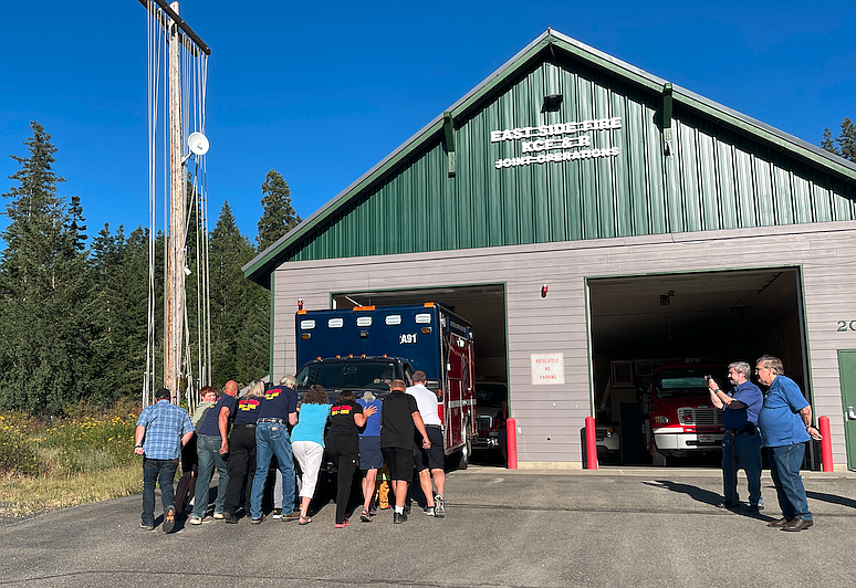 Friends and volunteers of East Side Fire District evening "push in" a new ambulance Tuesday into the Arrow Point Station during a firefighting tradition dating back to the 1800s.