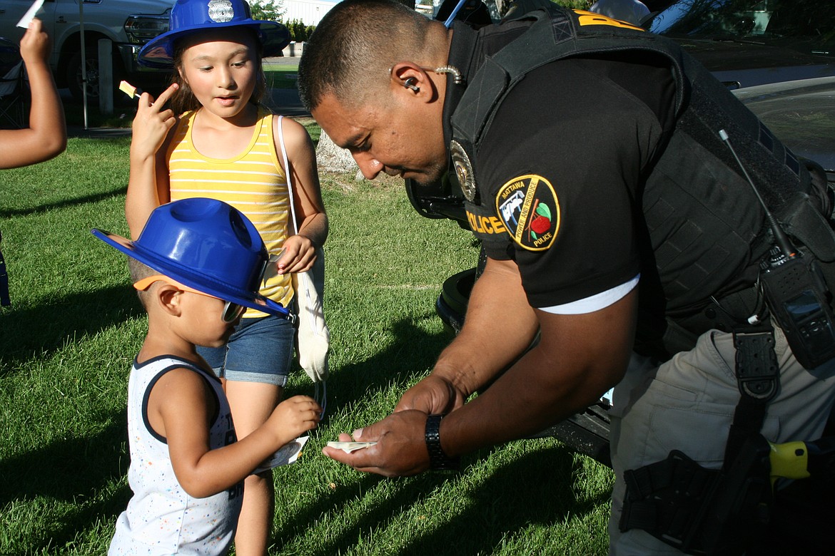 Francisco Araiza of the Mattawa Police Department hands out stickers at the 2022 National Night Out, the department’s first. For 2023 NNO will be combined with the city’s summer movie night.