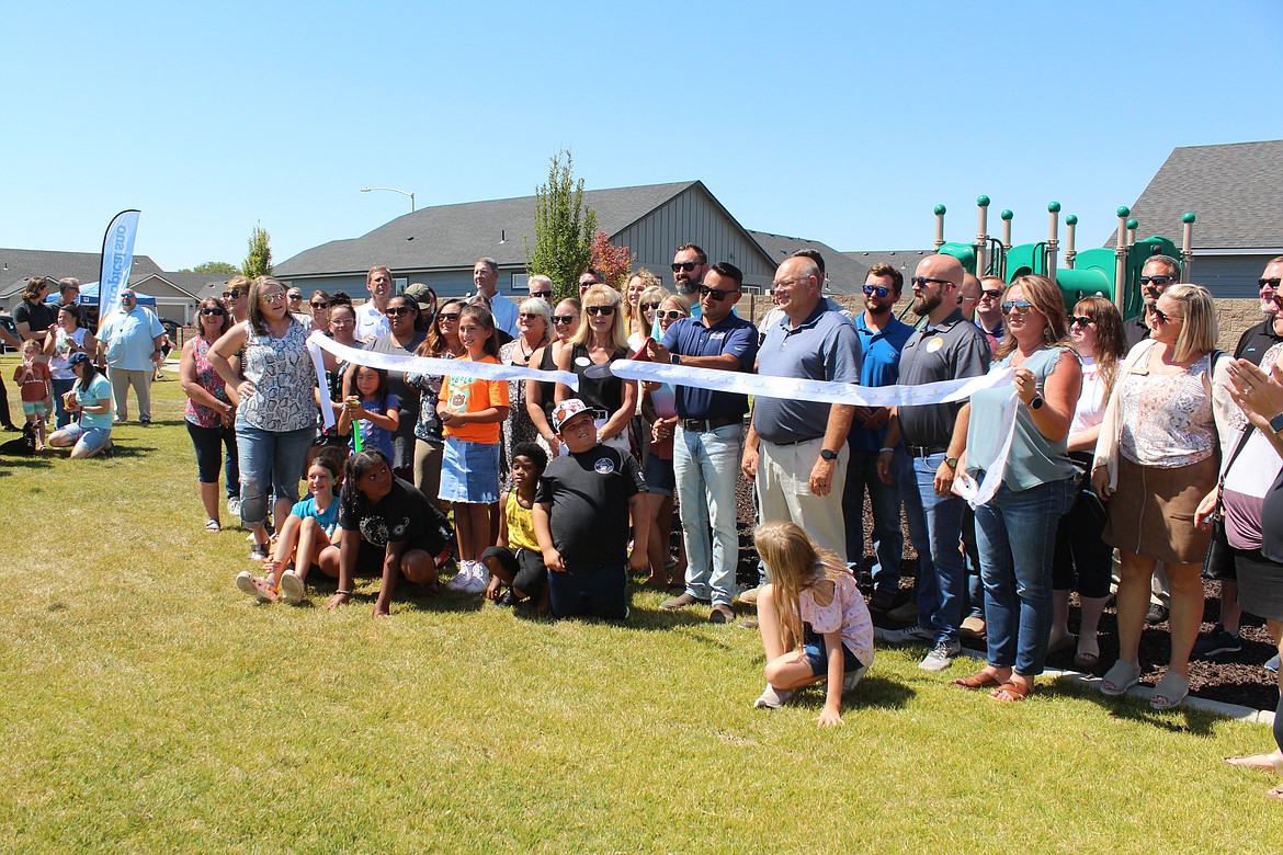 Flanked by members of the Moses Lake Chamber of Commerce and Moses Lake city officials, Hayden Homes employees cut the ribbon on the new Maple Grove Park.