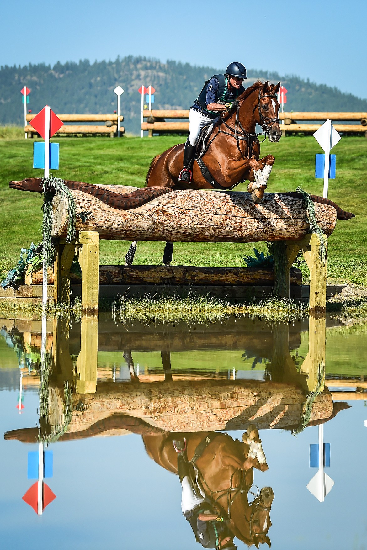 Kyle Carter rides Gstar Van De Klinkenberg over a jump into a water feature during CCI4*L cross-country at The Event at Rebecca Farm on Saturday, July 22. (Casey Kreider/Daily Inter Lake)