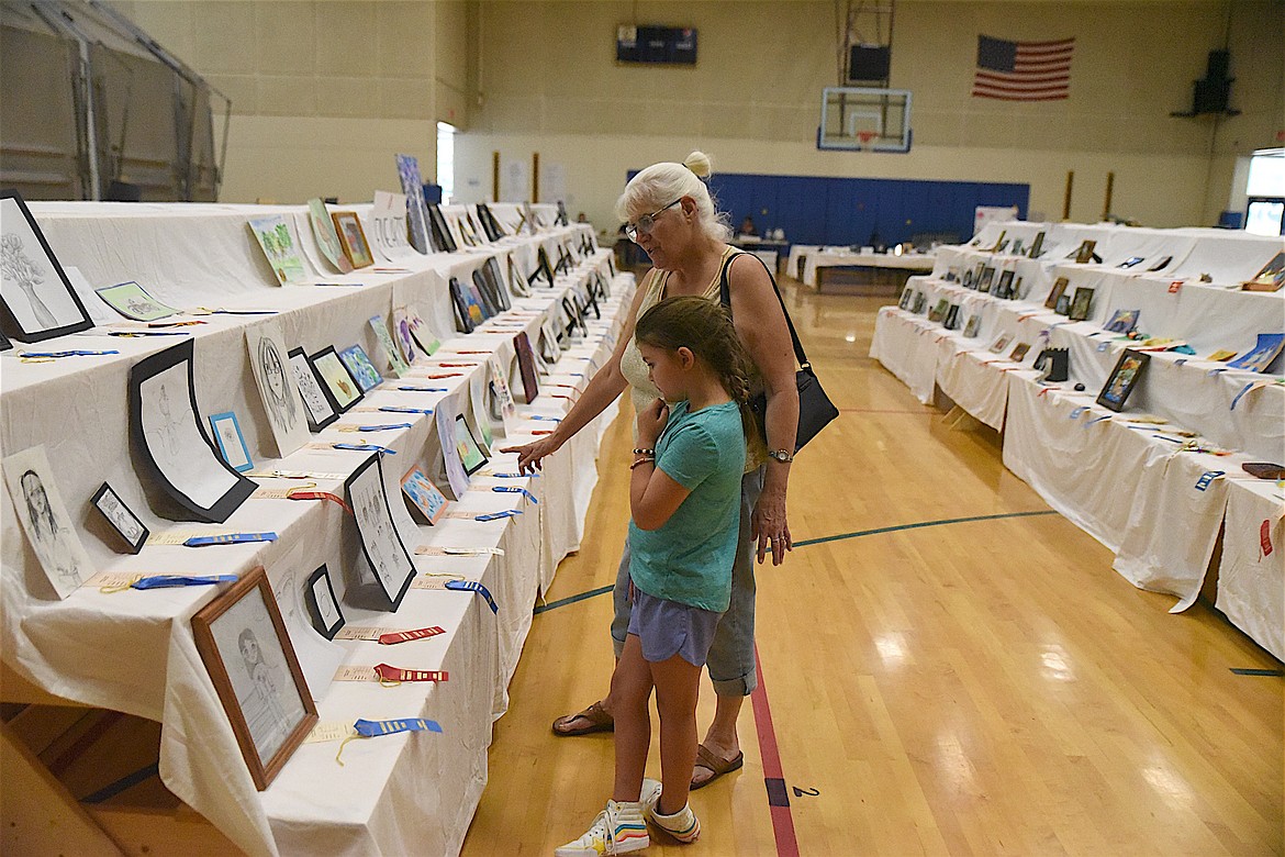 Belinda and Lacy Masters peruse the exhibits at the Lincoln County Junior Fair in the Libby Elementary School gymnasium Saturday afternoon. (Scott Shindledecker/The Western News)