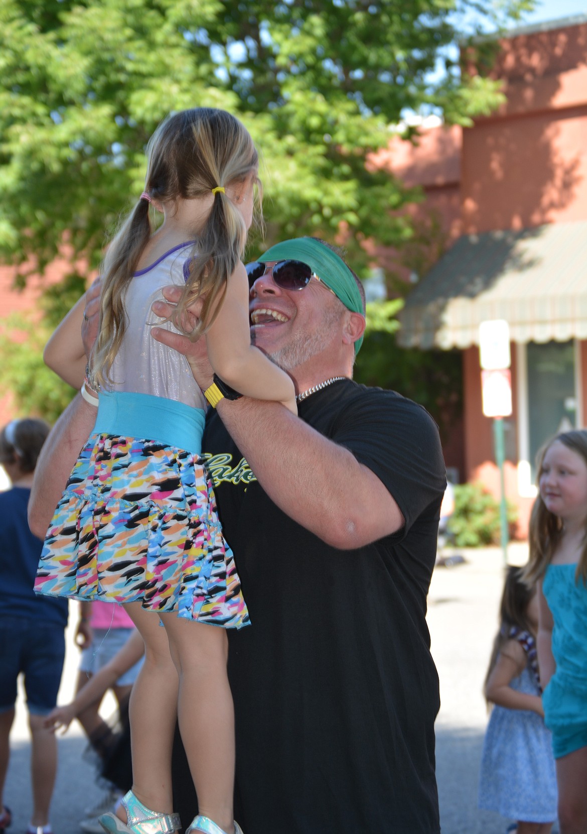 A man lifts a girl up while dancing in the street during the Rathdrum Days Parade.(CAROLYN BOSTICK/Press)