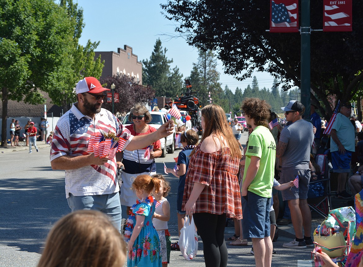 American flags are passed out to children in the crowd during the Rathdrum Days Parade on Main Street. (CAROLYN BOSTICK/Press)