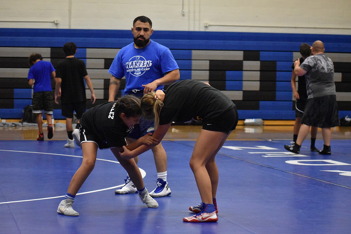 Clinician Chris Castillo, in blue, watches two Warden wrestlers as they practice newly learned techniques.