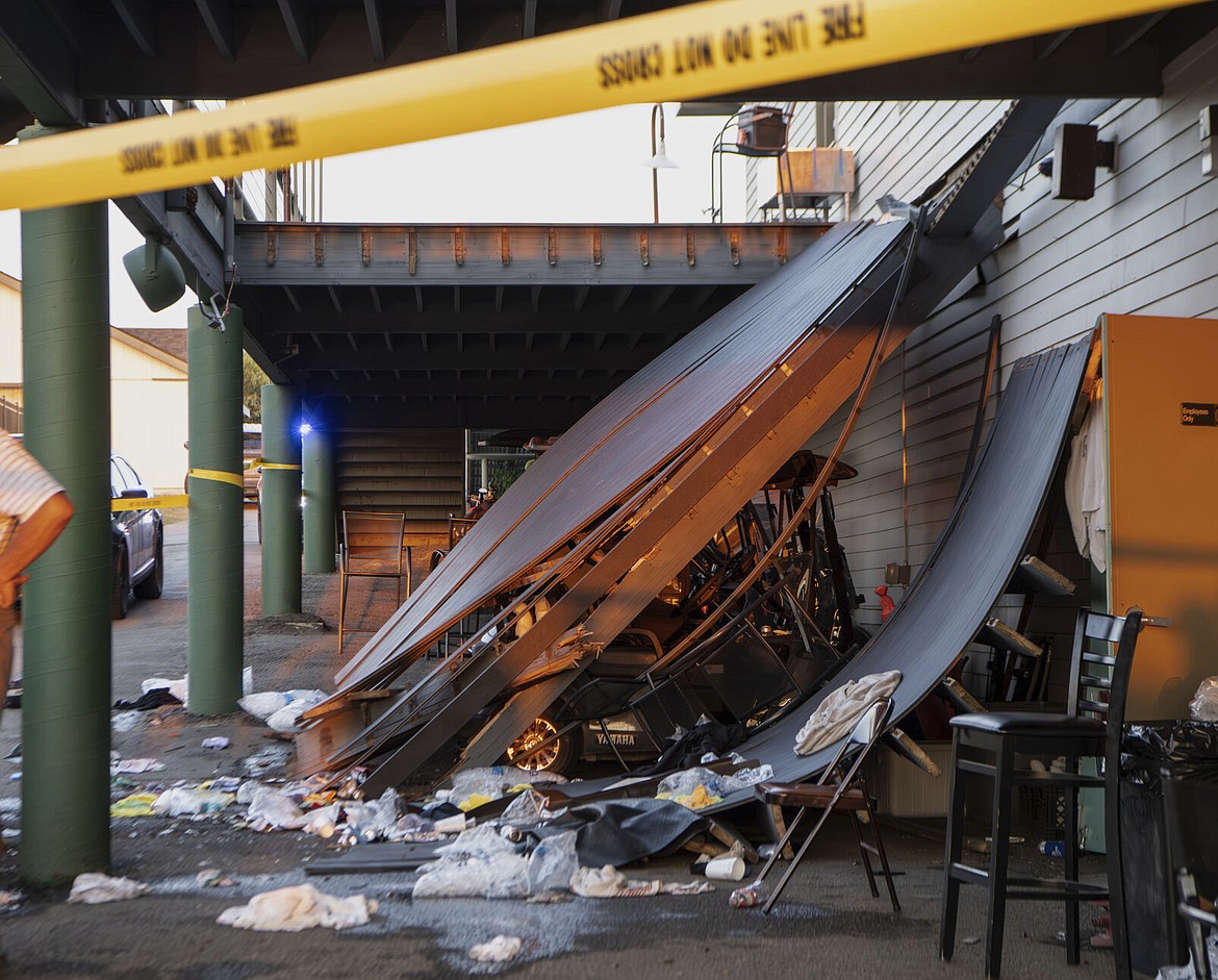 Police tape is wrapped around the scene of a deck collapse at Briarwood Country Club in Billings, Mont., Sunday, July 23, 2023. The deck collapsed, leaving up to 25 people injured on Saturday evening, police and news reports said. (Amy Lynn Nelson/The Billings Gazette via AP)