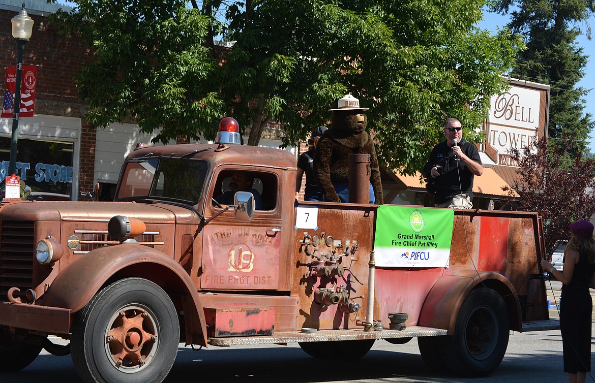 Parade Grand Marshal and Fire Chief Pat Riley and Smokey the Bear make their way down Main Street in an old Rathdrum fire truck.