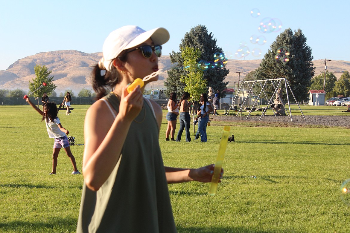 Seattle Community Church youth group members brought some games and toys, like the bubble wands, to Mattawa movie night. Ellen Choy, one of the youth group members, tried out the bubbles herself.